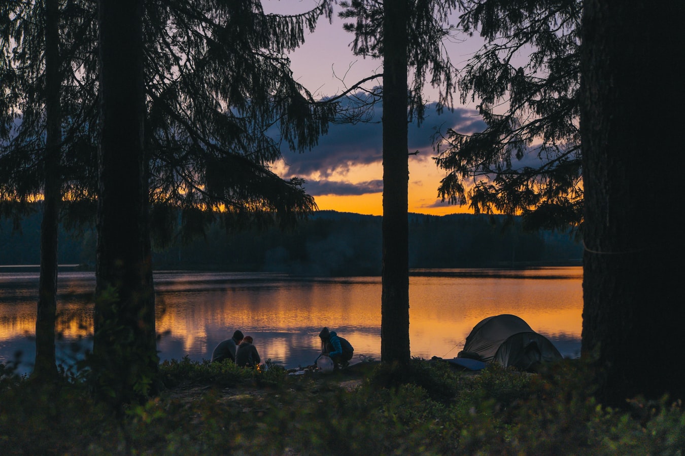 Matthew Davies image of people camping outdoors with a fire.