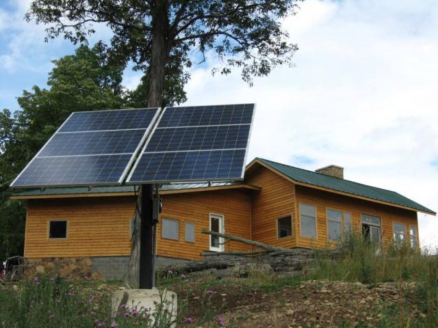 Matthew Davies image of an off grid house with solar panels in the backyard