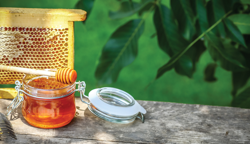 Matthew Davies image of honey in a mason jar and extra honey harvest